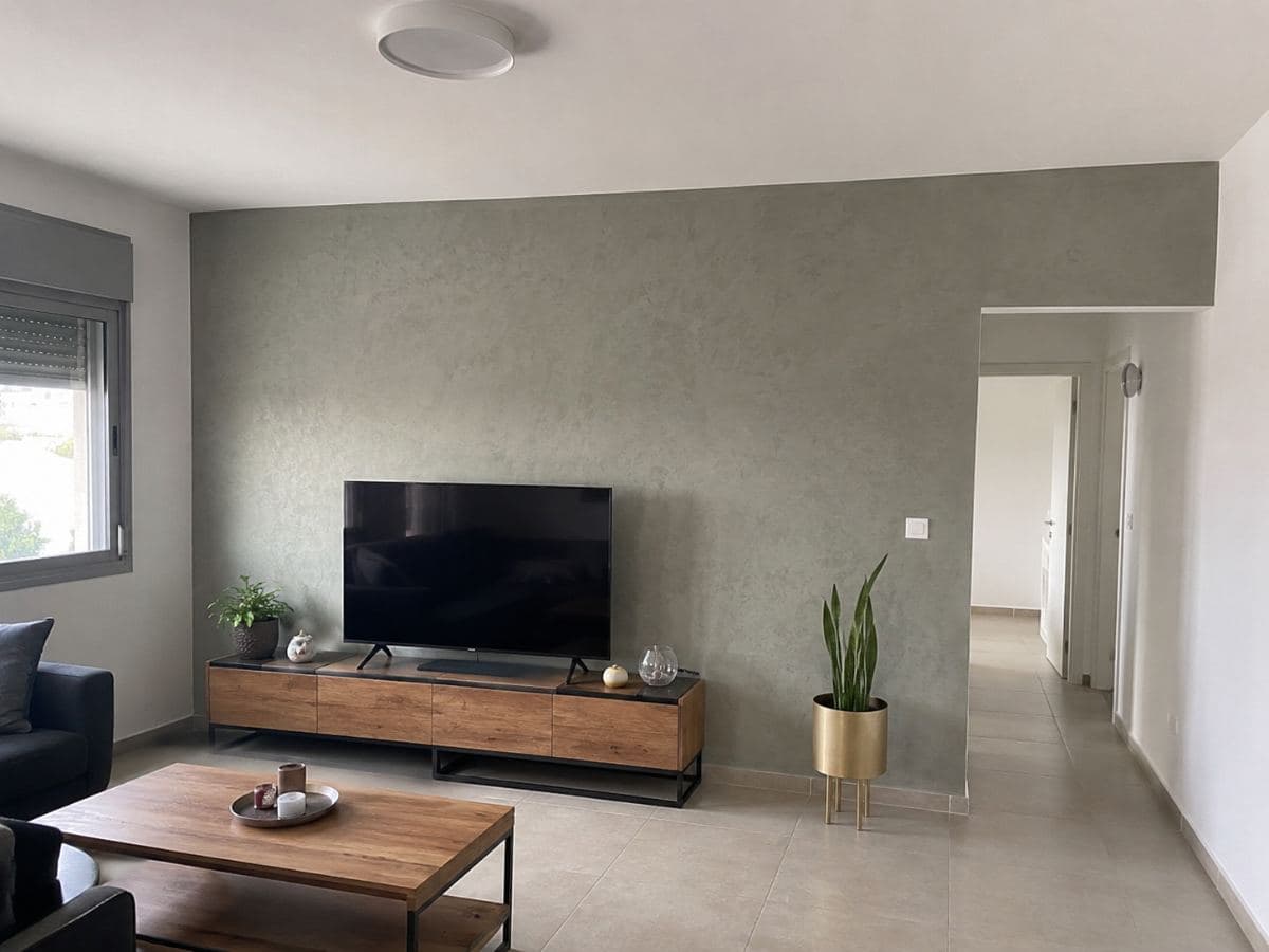 קיר סלון בגימור דקורטיבי עם מרקם, מאחורי אזור הטלוויזיה